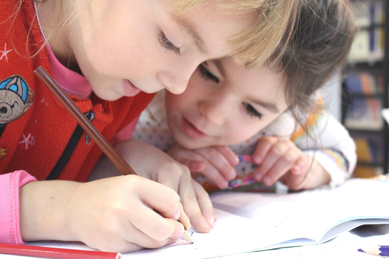 Two Kids Writing on a Notebook